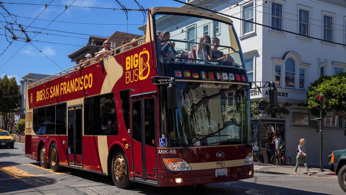 Red Big Bus next to a white brick building